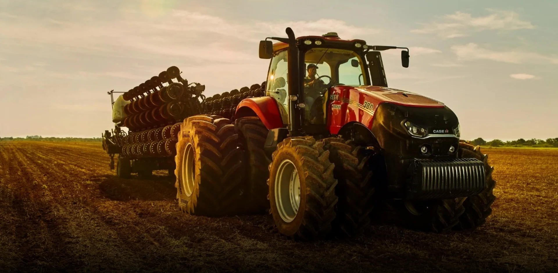 Trator agrícola vermelho trabalhando no campo